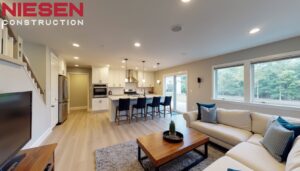 Bright, modern basement living space with high ceilings, recessed lighting, comfortable seating area, and wet bar, wide-angle real estate photography style